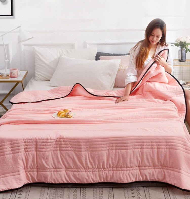 Lightweight premium cooling blanket in a hero view with thin-stripe pattern, showing breathable weave that helps disperse warmth on hot nights.