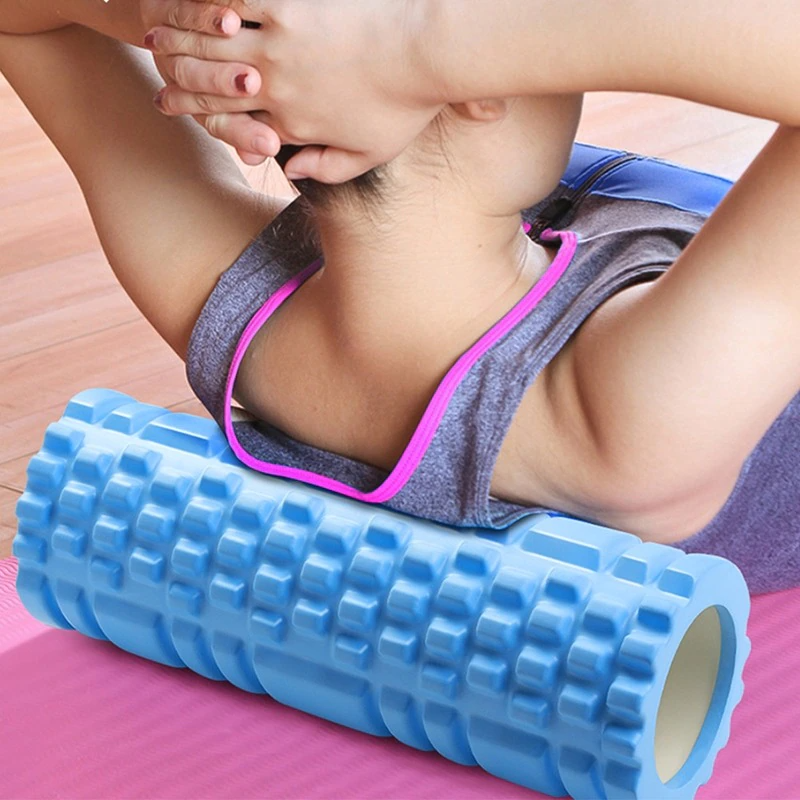 Person using a blue foam roller on a pink mat