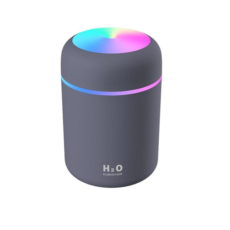 Portable aroma diffuser humidifier, front view, showing colourful LED ring and cup-style design with two spray modes and timed auto-off.